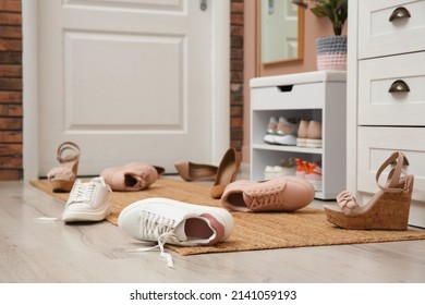 Stylish furniture and scattered shoes on floor in hall - Shutterstock ID 2141059193