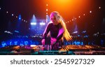 Stylish Girl Performing at a DJ Concert Live on Stage. Talented Music Producer Dancing, Mixing Energetic Dance Hits on Turntables. Young Beautiful Female Engaging with the Crowd