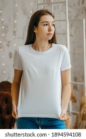 Stylish girl wearing white t-shirt posing in studio