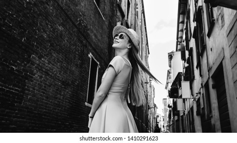 Stylish Girls In A Dress And Sunglasses Looking At The Building And Smile On The Street City On Black And White Photography