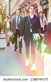 Stylish Glad Cheerful Positive Young Business Woman In Casual Dress Walking Through City Street In Crowd Of People