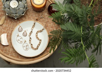 Stylish Golden Bijouterie And Candles On Wicker Table, Top View