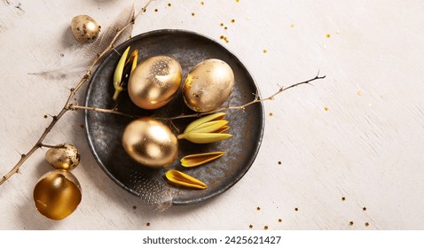 Stylish golden eggs easter concept. Easter gold eggs with flowers on light background. Happy easter card. Top view. Copy space.