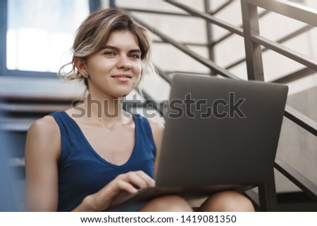 Stylish good-looking happy young female student prepare university presintation sit stairs alone outside hold laptop knees look camera pleased smiling working freelance, lead vanlife lifestyle