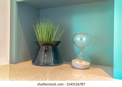 Stylish Grass Plant And Sand Timer On Bench