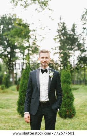 Stylish groom in a black suit on his wedding day