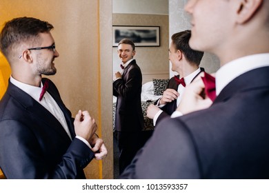 Stylish Groom Laughing And Having Fun With Groomsmen While Getting Ready In The Morning For Wedding Ceremony. Luxury Man