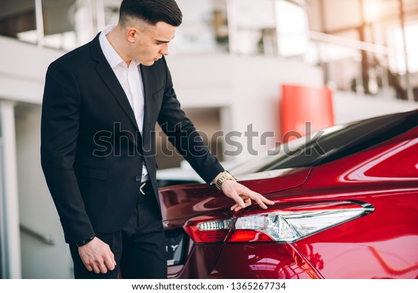 Stylish guy\
bought a red car at the car\
dealership