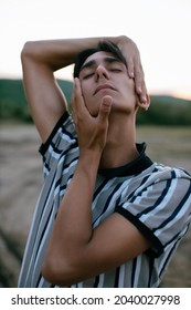 Stylish guy model posing in front of the camera. A man in nature.