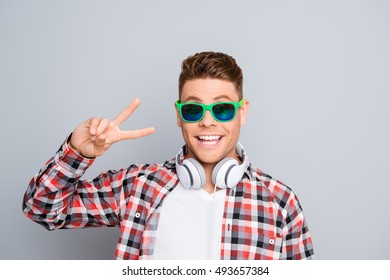 Stylish Guy In Spectacles And Headphones Showing Two Fingers