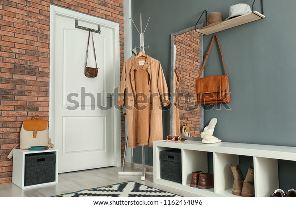 Stylish\
hallway interior with mirror and hanger\
stand
