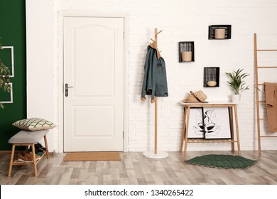 Stylish hallway interior with shoe storage bench, hanger stand and table - Shutterstock ID 1340265422