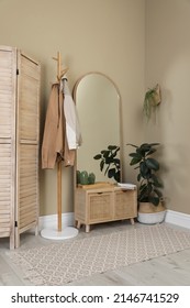 Stylish Hallway Room Interior With Wooden Commode, Coat Rack And Large Mirror