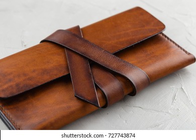 Stylish handmade brown leather wallet on gray background