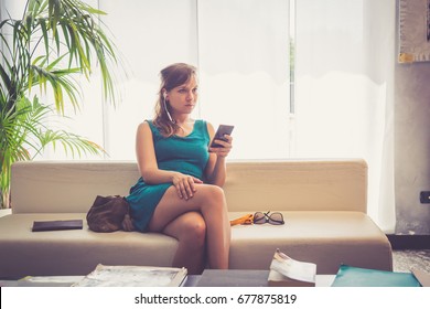 Stylish handsome with blue dress talking on a smartphone sit on a sofa in the hall of the hotel - Shutterstock ID 677875819