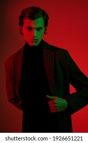 Stylish Handsome Young Man In Elegant Clothes Poses At Studio In Red And Green Light. Men's Style. 