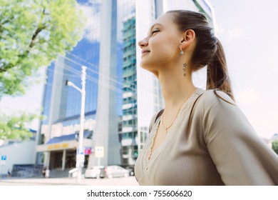 stylish happy girl in beige dress walking around the city, enjoying the weather
