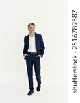 Stylish happy middle aged business man, mature professional executive, businessman leader fashion model wearing suit looking away walking isolated on white background, vertical full body photo.