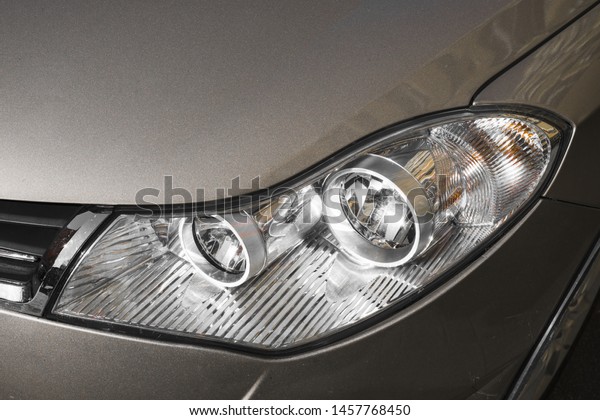 Stylish headlight of\
dark grey automobile