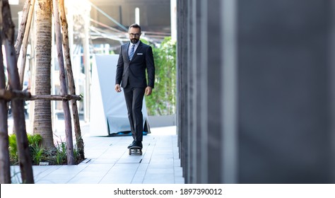 Stylish hipster bearded man skater riding a longboard go to working at the city.