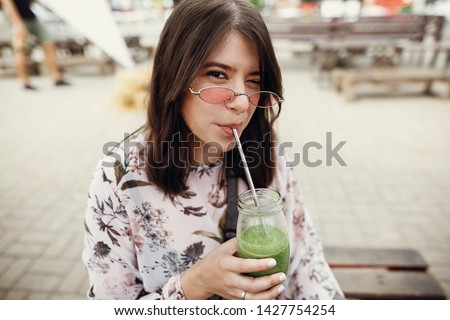 Similar – Frau mit Sonnenbrille, die im Freien grünen Gemüse-Smoothie trinkt.