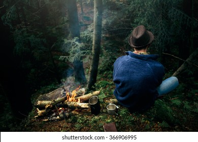 stylish hipster traveler camping in sunny forest in the mountains - Powered by Shutterstock