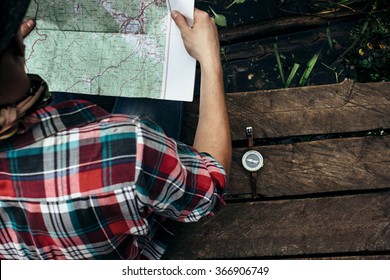 stylish hipster traveler exploring map at sunny forest and lake in the mountains - Powered by Shutterstock