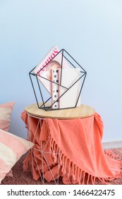 Stylish Holder With Books And Magazine On Table In Room