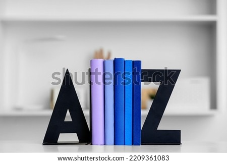 Stylish holder with books on table in room