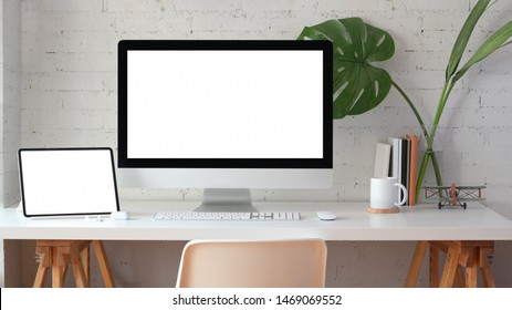 Stylish Home Office With Blank Screen Desktop Computer And Tablet With Stationery