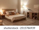 Stylish interior of bedroom with comfortable bed, lamp and shelving unit at evening