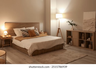 Stylish interior of bedroom with comfortable bed, lamp and shelving unit at evening