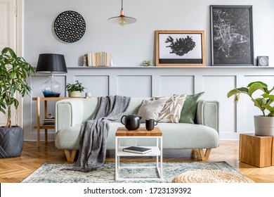 Stylish interior design of living room with modern mint sofa, wooden console, cube, coffee table, lamp, plant, mock up poster frame, pillows, plaid, decoration and elegant accessories in home decor.