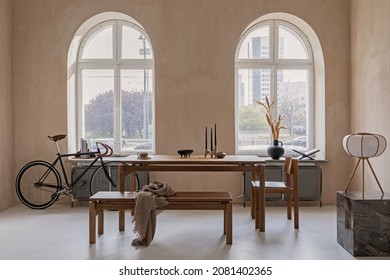 Stylish interior design of spacious dining room with wooden dining table, armchairs and beautiful personal accessories. Modern home decor. Structure wall. Rustic minimalitic inspiration. Template.
