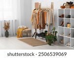 Stylish interior of dressing room with autumn clothes and accessories