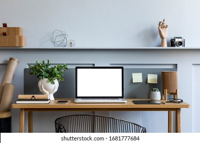 Stylish interior of home office room with mock up laptop screen, wooden desk, plant, books, notes, chair, wood paneling and elegant office accessories in design apartment. - Powered by Shutterstock