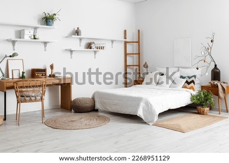 Stylish interior of light bedroom with Easter decor and comfortable bed
