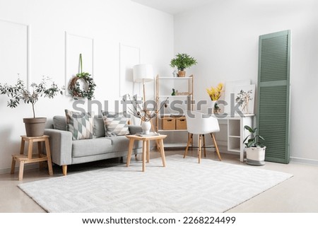 Stylish interior of light living room with Easter decor