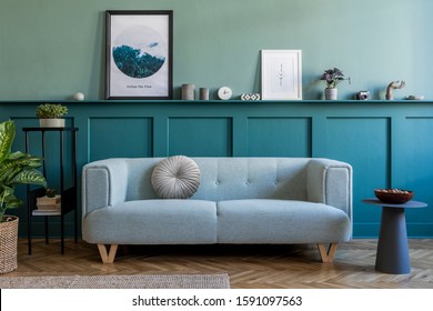 Stylish interior of living room with mint sofa, design furnitures, plants, pillow and elegant accessories. Green wood panelling with shelf. Modern home decor. Mock up poster frame. Template. 