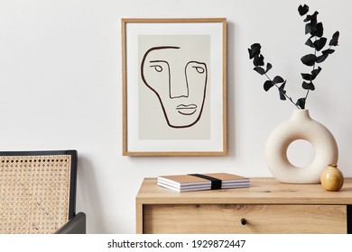 Stylish interior of living room with mock up poster frame, wooden commode, book, eucalyptus leaf in ceramic vase and elegant personal accessories. Minimalist concept of home decor. Template. - Powered by Shutterstock