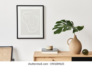 Stylish interior of living room with mock up poster frame, wooden commode, book, tropical leaf in ceramic vase and elegant personal accessories. Minimalist concept of home decor. Template. - Powered by Shutterstock