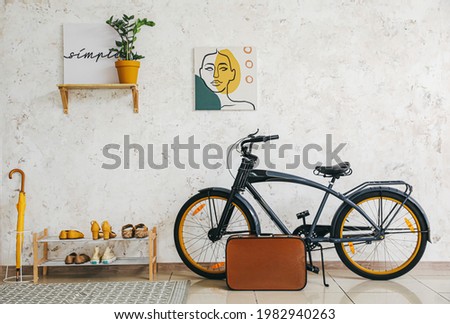 Stylish interior of modern hall with shoes on stand and bicycle