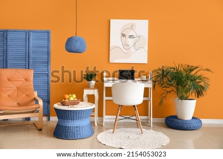 Stylish interior of modern room with workplace and folding screen