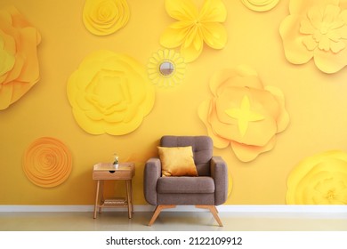 Stylish interior of room with armchair and beautiful flowers on wall