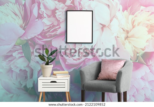 Stylish interior of a living room with armchair and beautiful peony flowers mural. 
