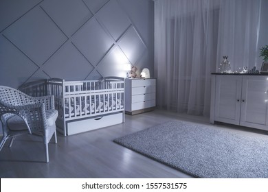 Stylish Interior Of Room With Baby Bed At Night