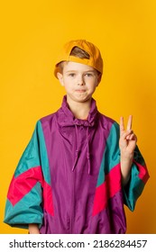 Stylish Kid Boy In 80s Sport Suit And Cap On Yellow Background