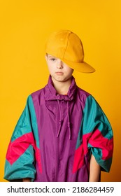 Stylish Kid Boy In 80s Sport Suit And Cap On Yellow Background