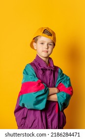 Stylish Kid Boy In 80s Sport Suit And Cap On Yellow Background