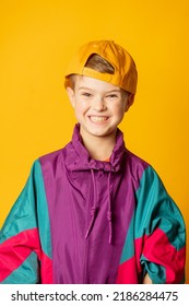 Stylish Kid Boy In 80s Sport Suit And Cap On Yellow Background